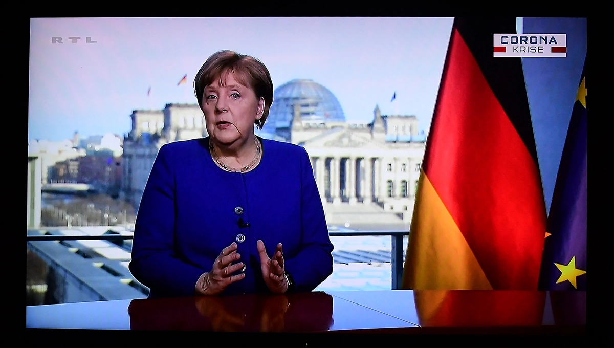 Angela Merkel im TV, neben ihr eine Deutschland-Flagge. picture alliance/dpa/Revierfoto | Revierfoto