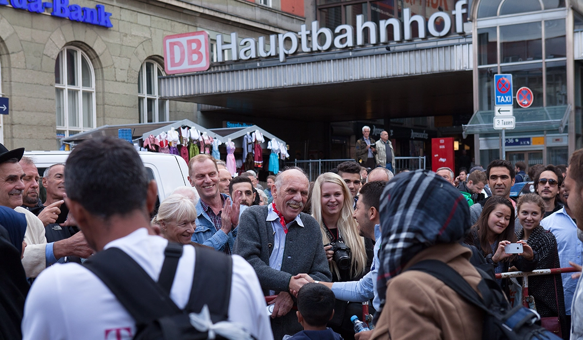 Incoming people being greeted by a crowd at Munich central station. picture alliance / SZ Photo | Florian Peljak